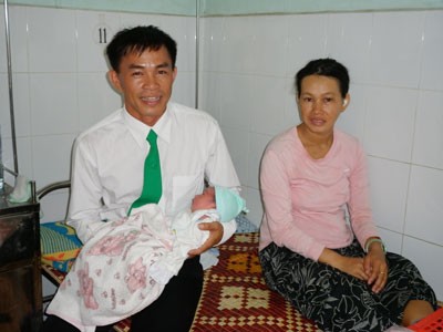 Driver Nguyen Van Con holds the newborn baby (Photo: SGGP)
